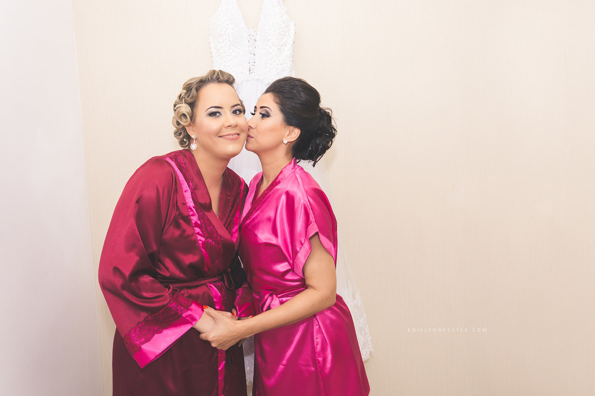 noiva com madrinha dando beijo no rosto