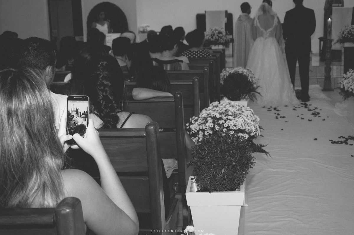 convidado tirando foto dos noivos no casamento