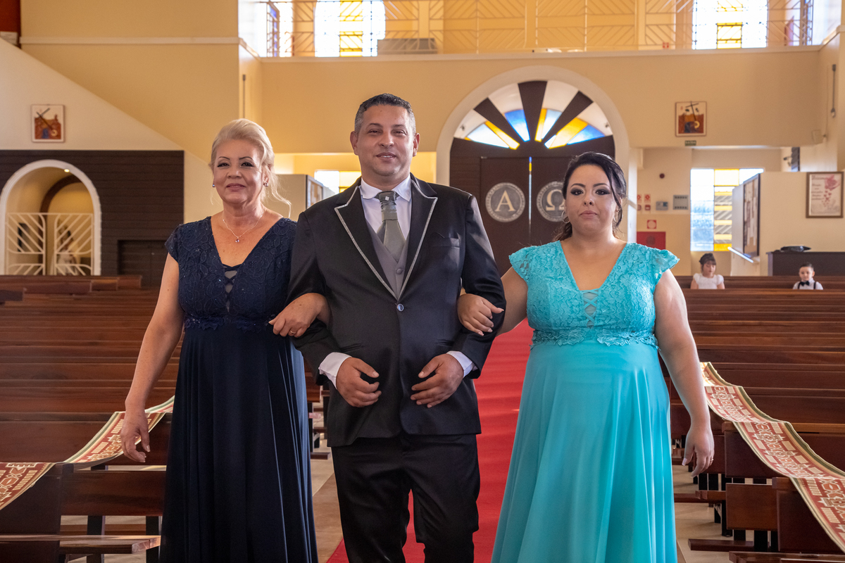 O noivo sendo Conduzido pelo corredor pela Mamãe e a Irmã