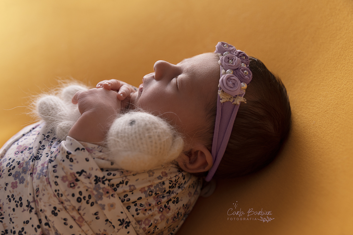 foto-bebê-wrap-florido-lilás-ursinho-e-headband-close-em-contra-luz