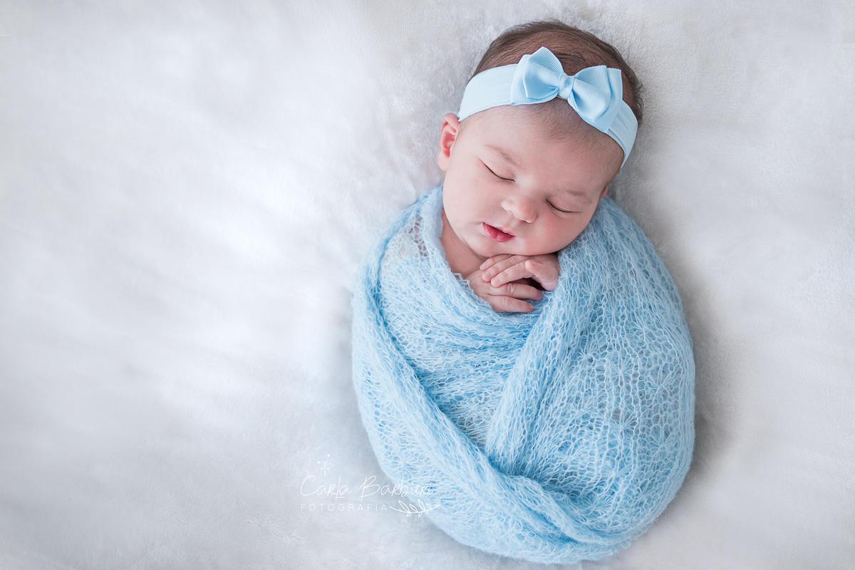 Júlia enrolada em wrap azul com headband de mesma cor. Manda gelo.
