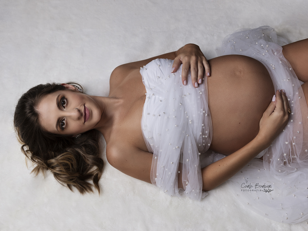 foto da futura mamãe deitada em tapete de pele