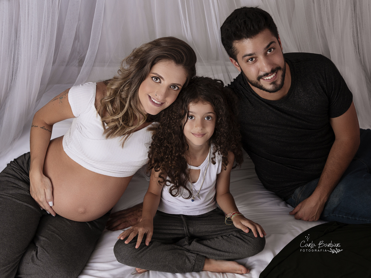 fotografia de família em book gestante sentados na cama