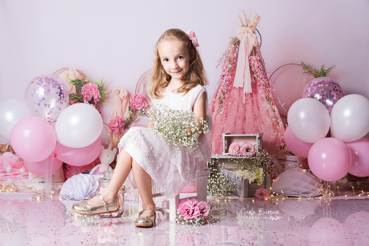 Letícia segurando um buqueê de flores em seu ensaio de 6 anos