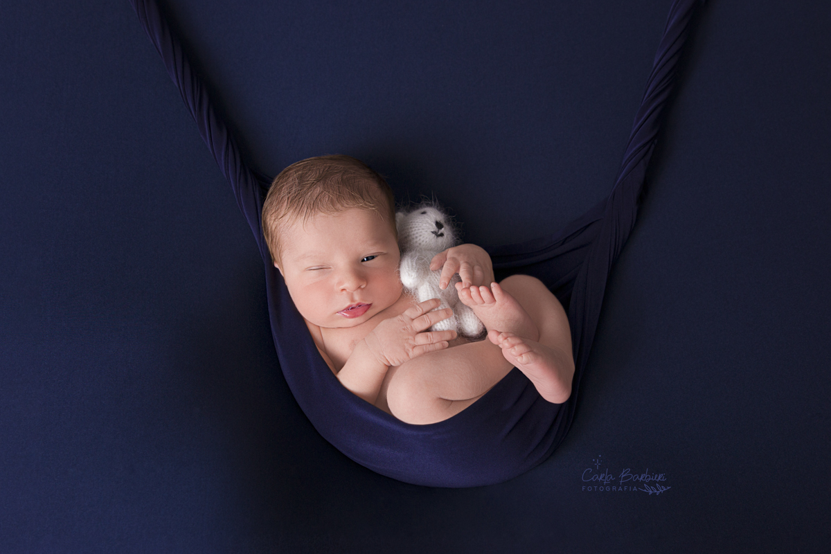 newborn pedro de olho aberto na rede com ursinho