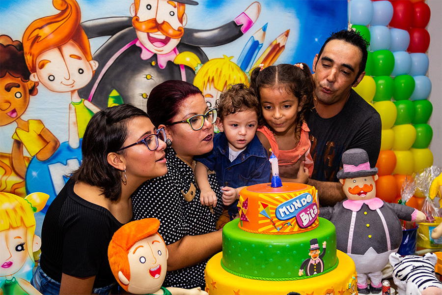 Família apagando a vela do bolo
