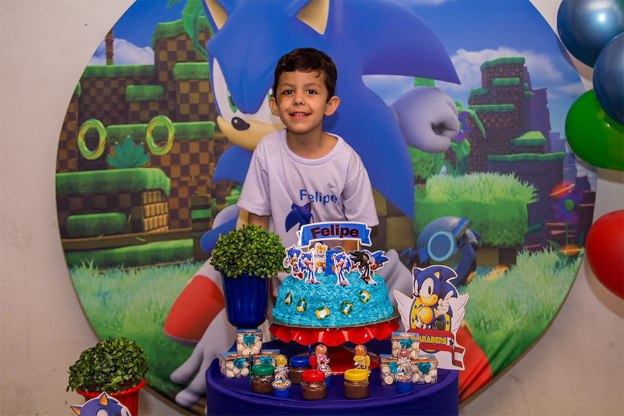 Aniversariante em frente ao bolo