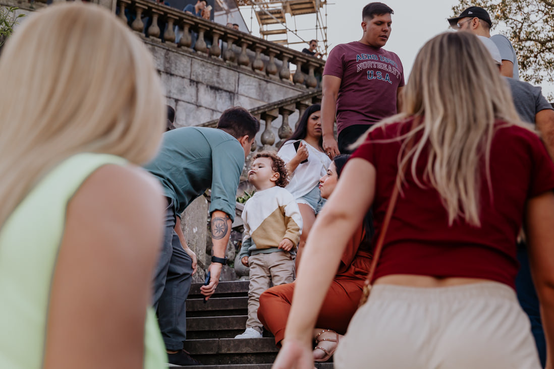 pais e filho de 3 anos fazem biquinho pra dar selinho na escadaria do cristo redentor em meio aos turistas