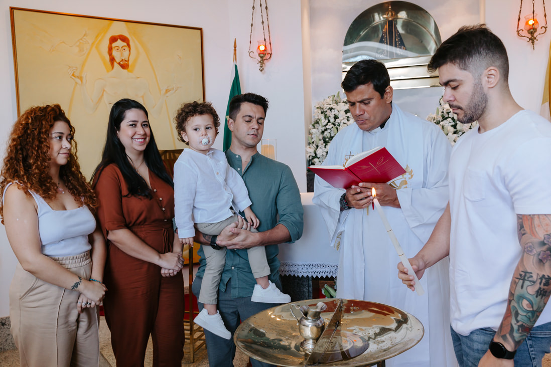 pais, padrinhos e padre em volta da pia batismal do cristo redentor
