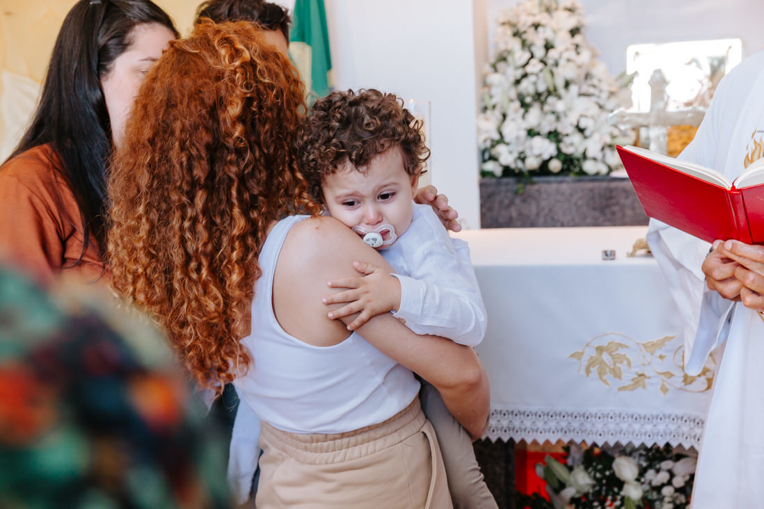 menino com cara de choro apos ritual de batismo no cristoi redentor