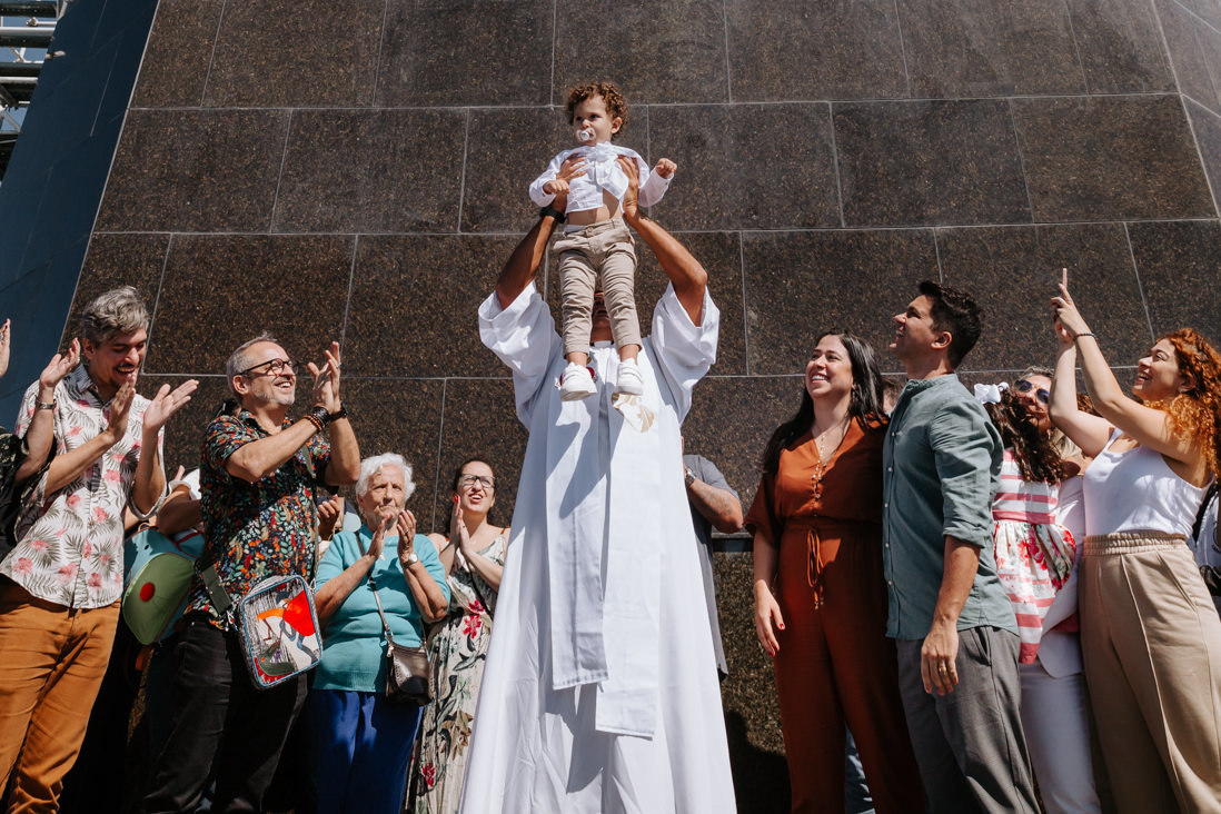 padre apresenta menino em batismo no cristo redentor