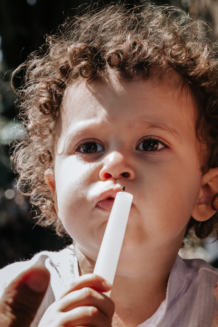 crianca assopra vela em seu batismo