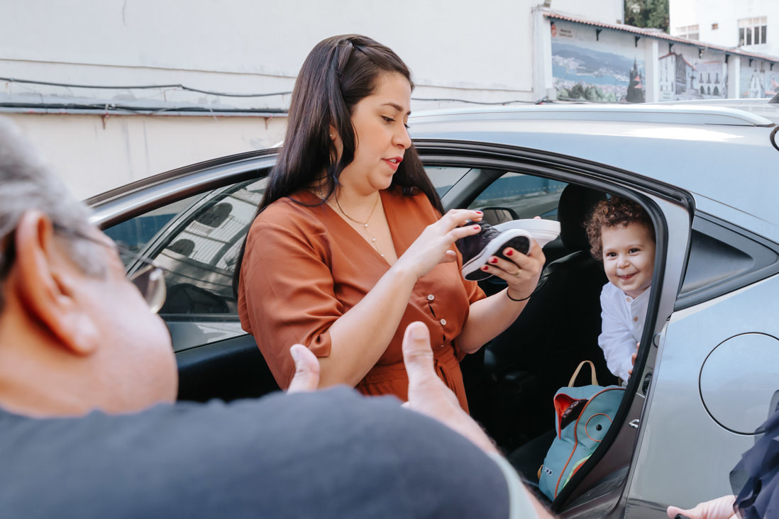 criança dentro do carro sorri para avo que esta ao lado de fora 