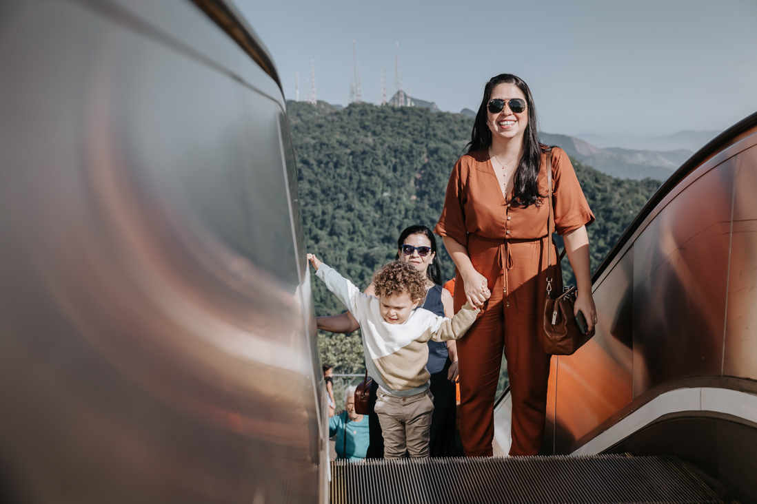 avo, neto e mae nas escadas rolantes do cristo redentor num dia de sol para o batizado