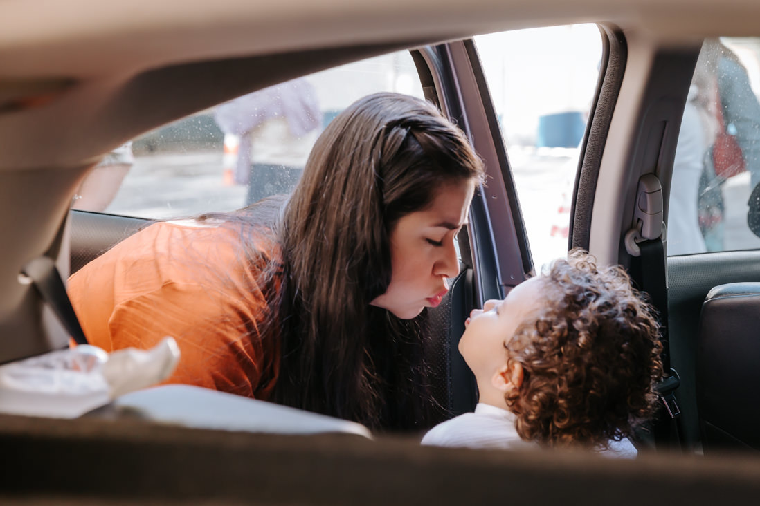 filho e mae dentro do carro fazem biquinho para darem beijo