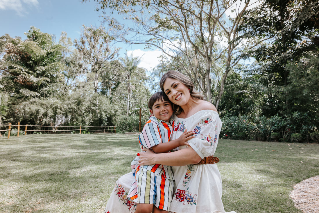 mae agachada e filho de 4 anos em seu colo sorriem e posam para foto em festa de aniversario infantil no espaço jamboo em vargem grande no RJ
