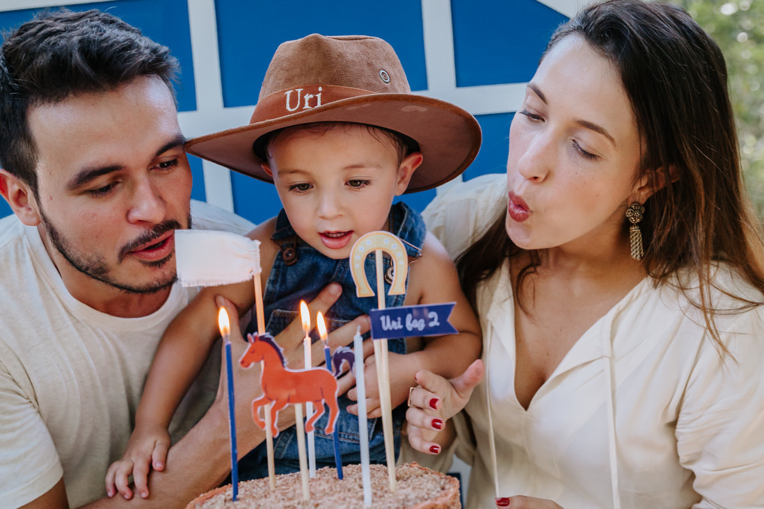 familia assopra as velinhas de bolo