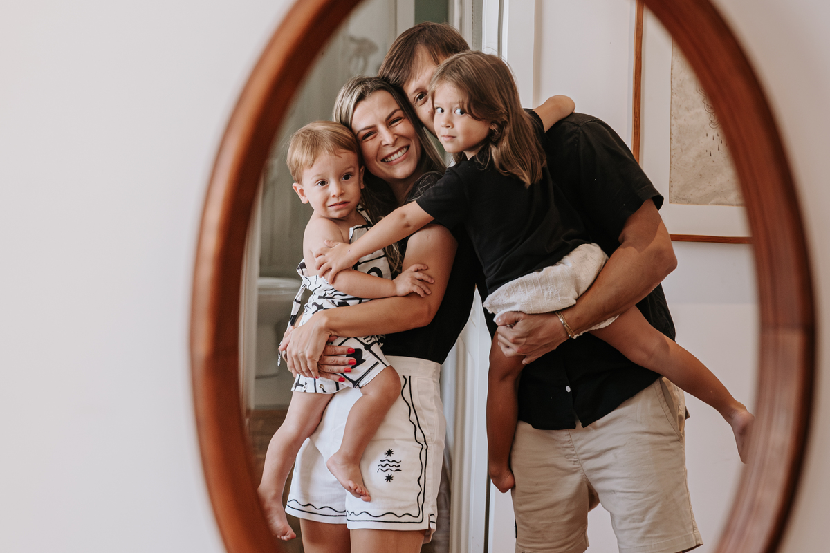 fotos dos quatro membros de uma família refletida no espelho oval antigo da casa