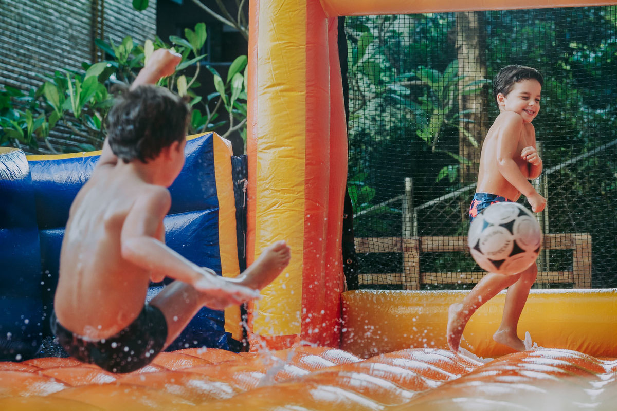 Fotografia menino jogando 
 futebol de sabão na sua festa de aniversário infantil no play do condomínio na Lagoa Rodrigo de Freitas no Rio de Janeiro