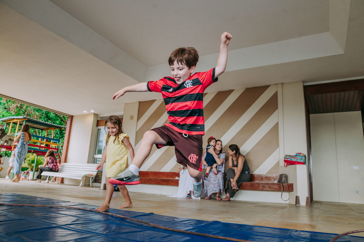 Fotografia de criancas participando de recreação infantil pulando corda durante festa de irmãos no play de condomínio na Lagoa Rodrigo de Freitas no Rio de Janeiro