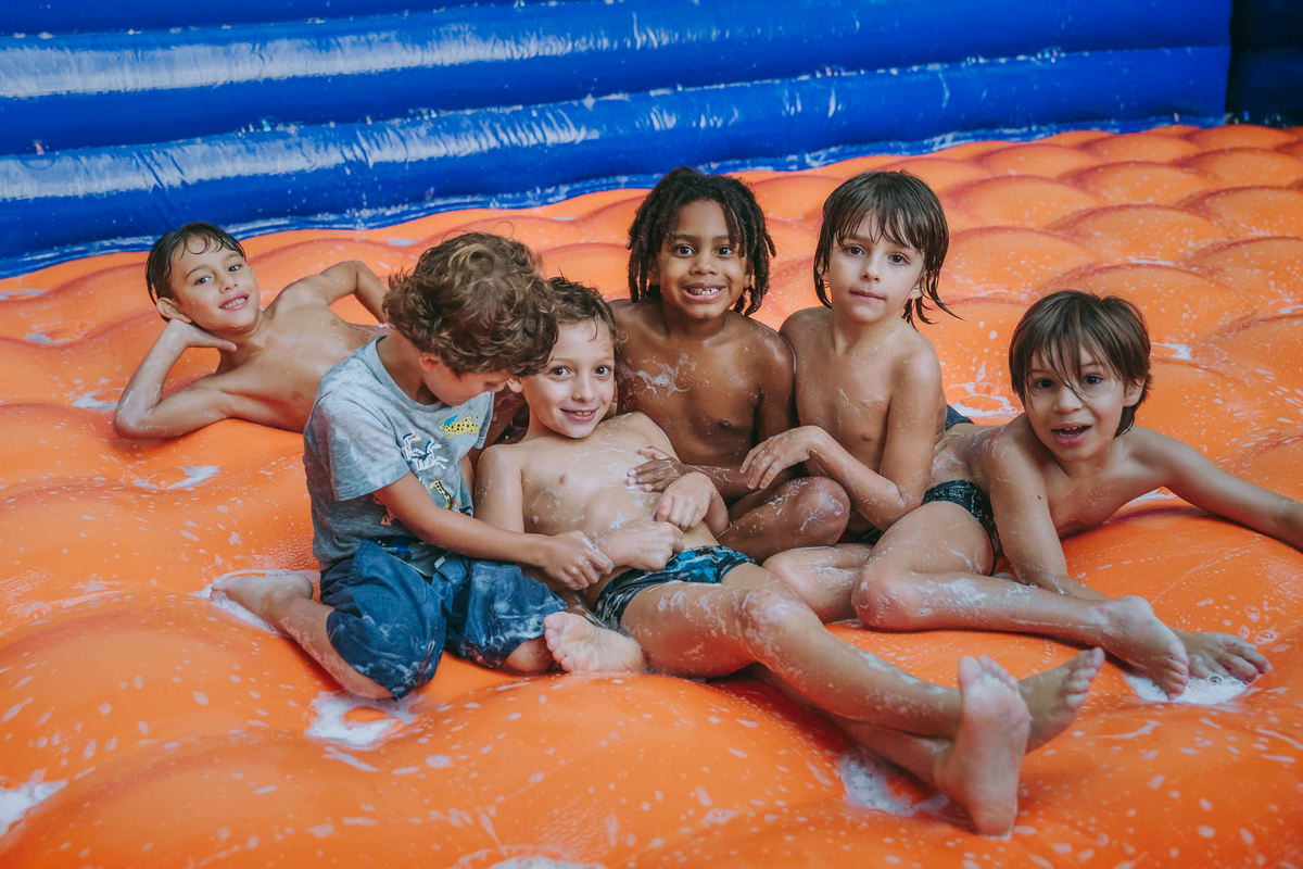 Fotografia de amigos posando para foto durante partida de 
 futebol de sabão em festa de aniversário infantil no play do condomínio na Lagoa Rodrigo de Freitas no Rio de Janeiro
