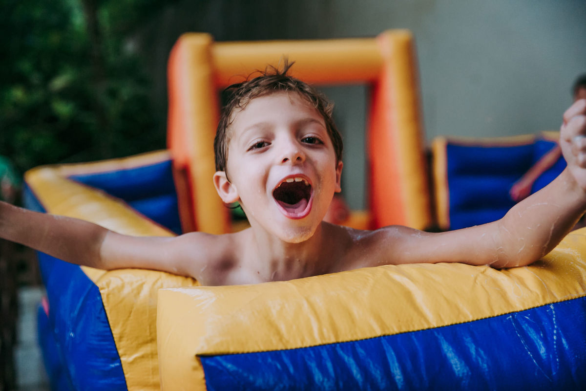 Fotografia menino comemorando gol no futebol de sabao em festa de aniversário infantil no play do condomínio na Lagoa Rodrigo de Freitas no Rio de Janeiro