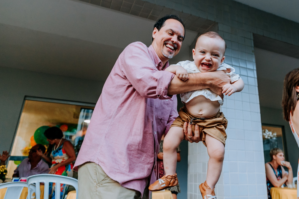 Fotografia de pai brincando com seu filho de 1 ano em seu aniversário