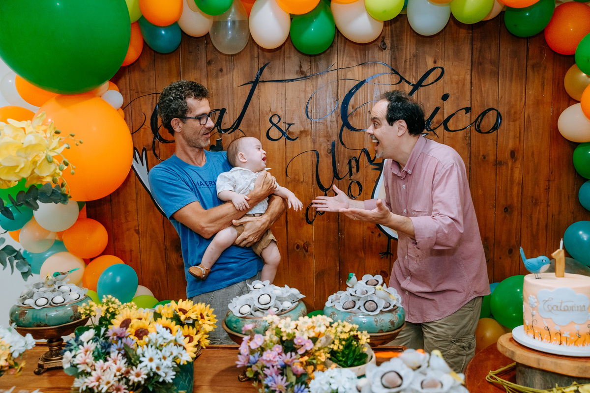 Fotografia do padrinho e do pai do aniversariante na mesa do bolo