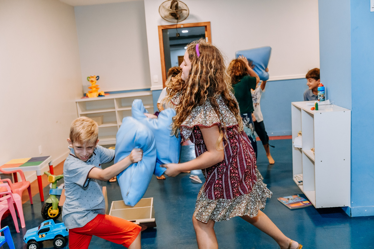 Fotografia de crianças fazendo guerra de travesseiro