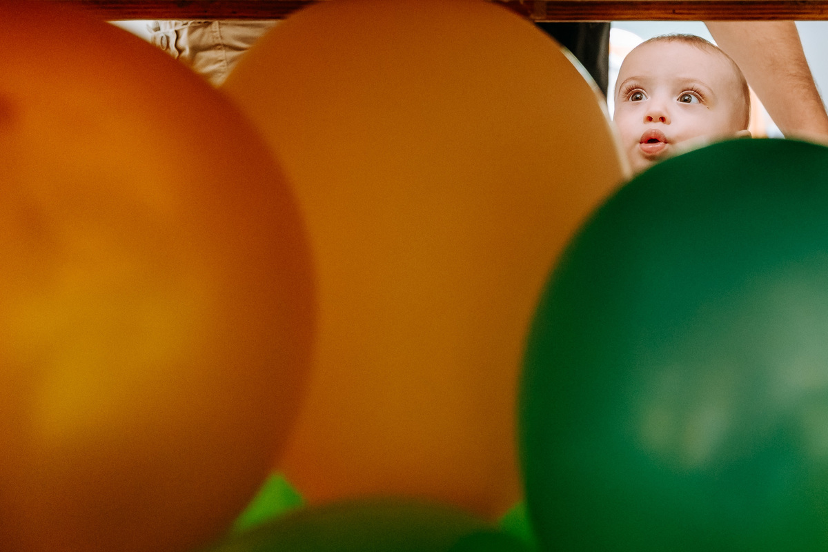 Fotografia de menino de 1 ano em sua festa de aniversário entre as bolas da ornamentação