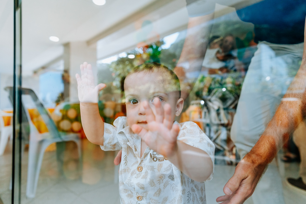 Fotografia de criança curiosa através do vidro da porta