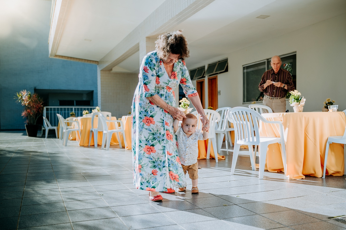 Fotografia de criança dando os primeiros passinhos com a avó em sua festa de aniversário