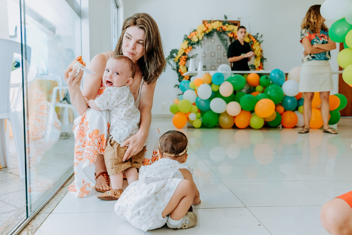 Fotografia de gêmeos em sua festa de aniversário de 1 ano menino chorando