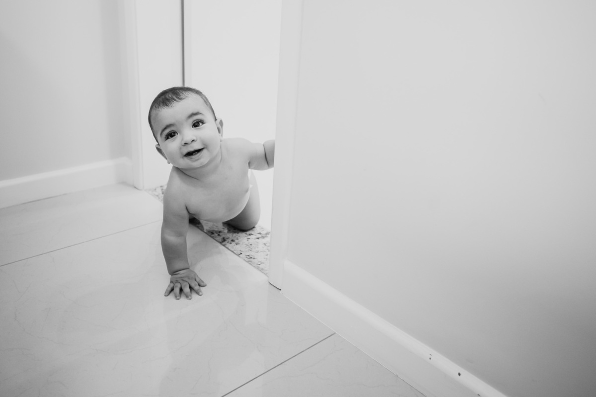 Fotografia de bebê engatinhando pela casa