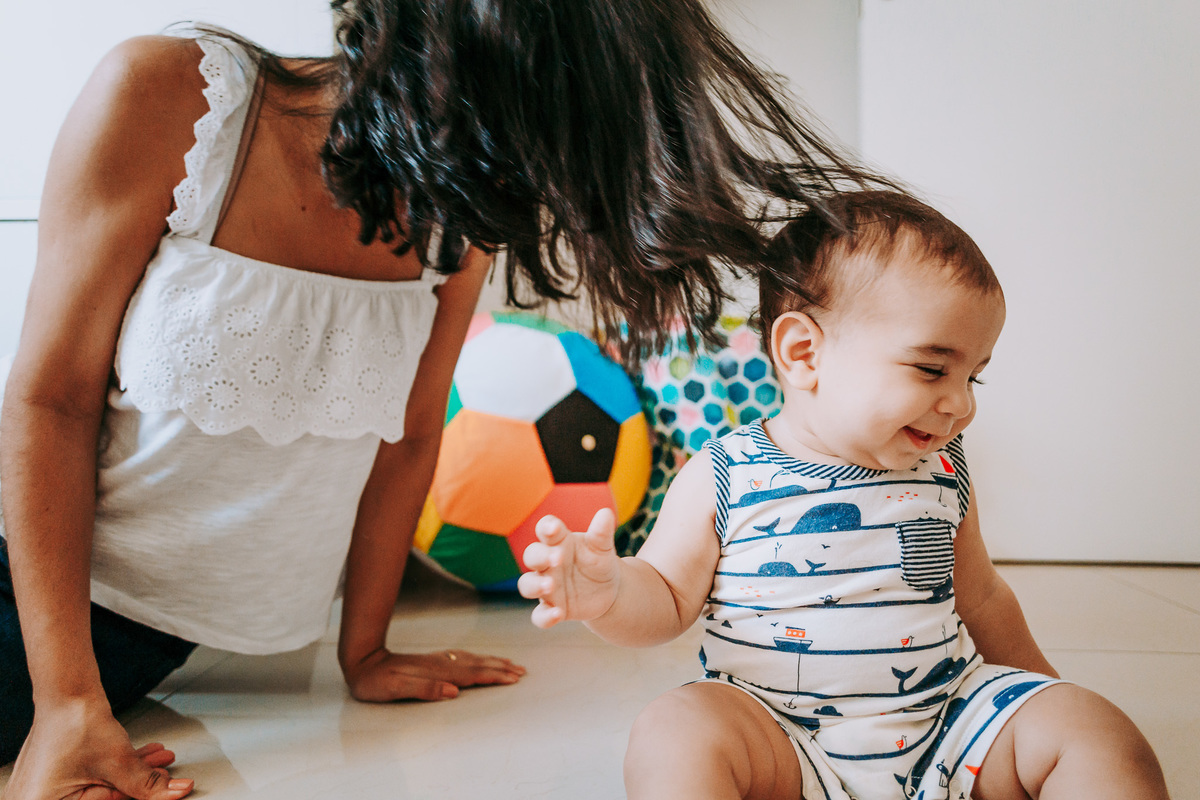 Fotografia de família lifestyle com a mãe brincando com o bebê