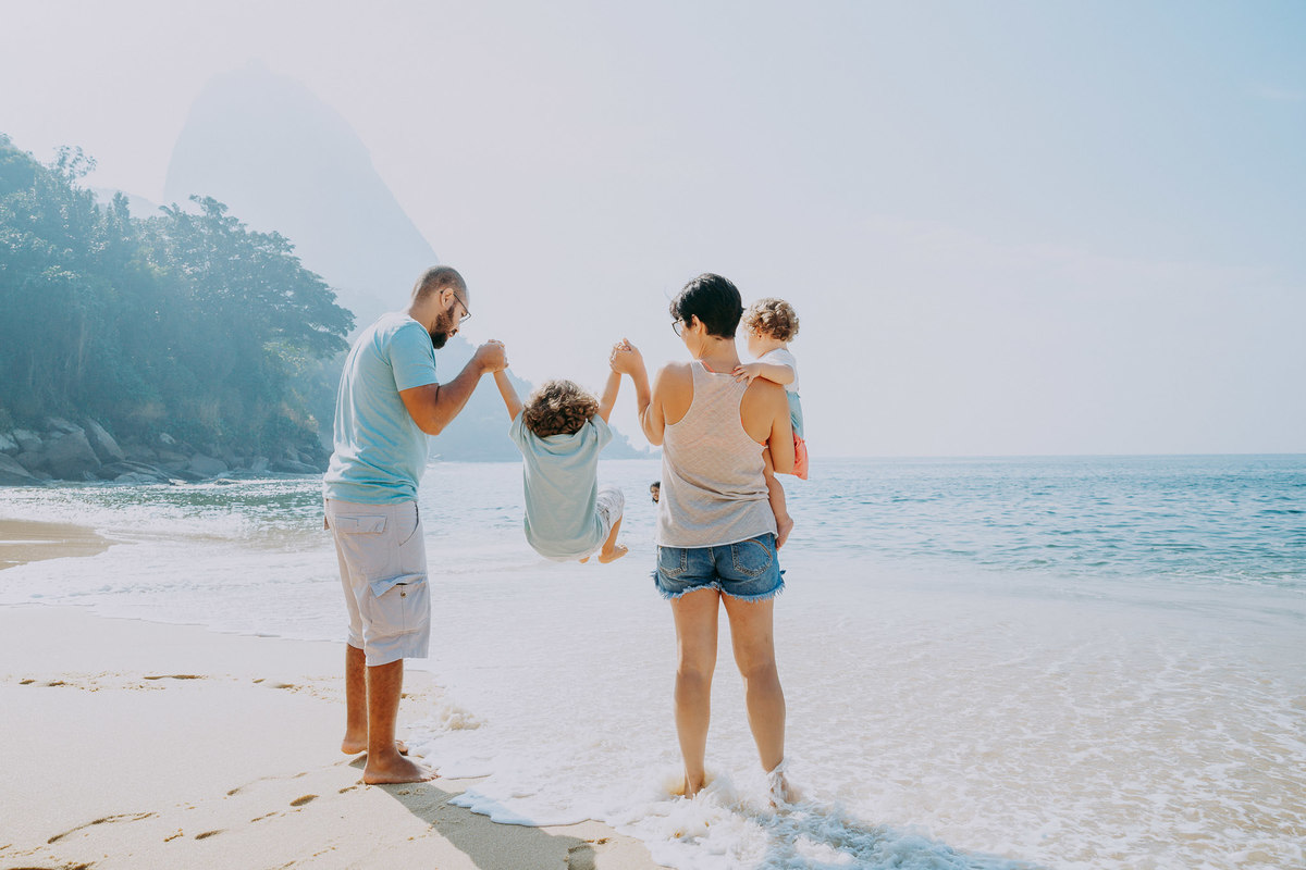 Fotografia de família de frente para o mar durante ensaio família na Praia Vermelha no RJ