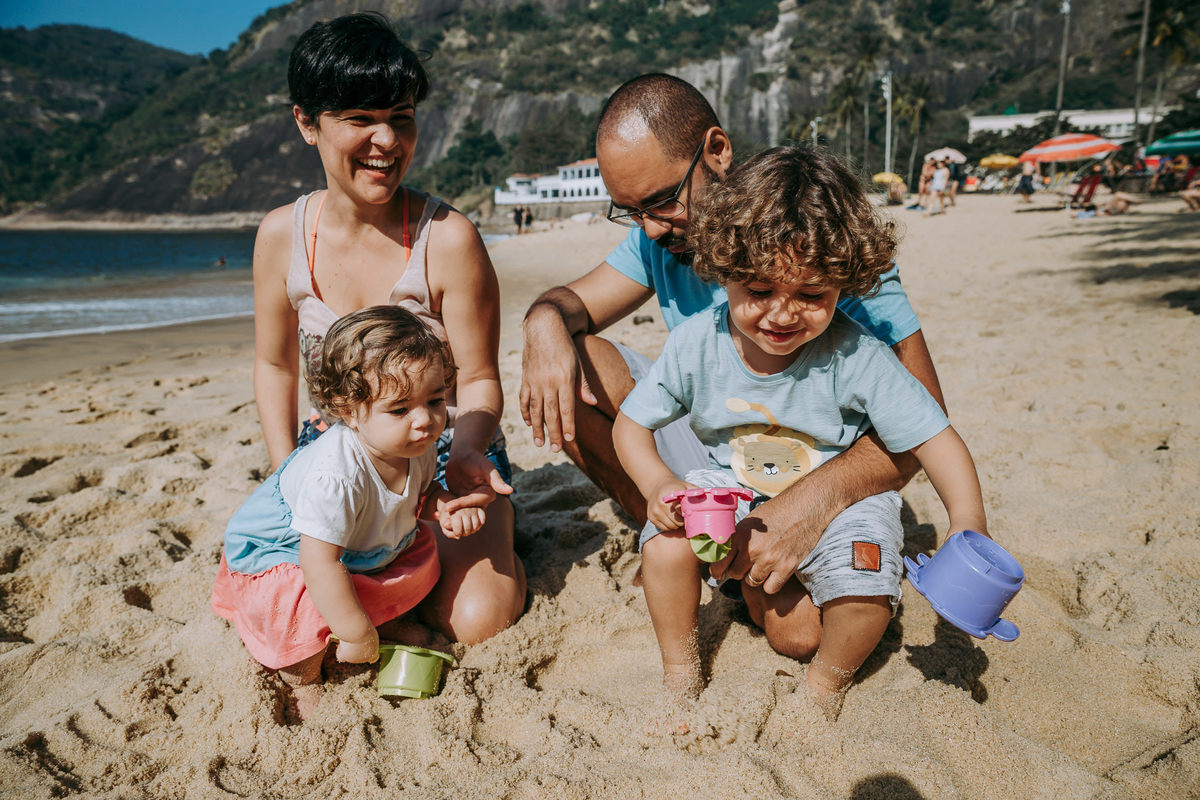 Fotografia de irmãos brincando na areia da Praia Vermelha no RJ durante ensaio fotográfico