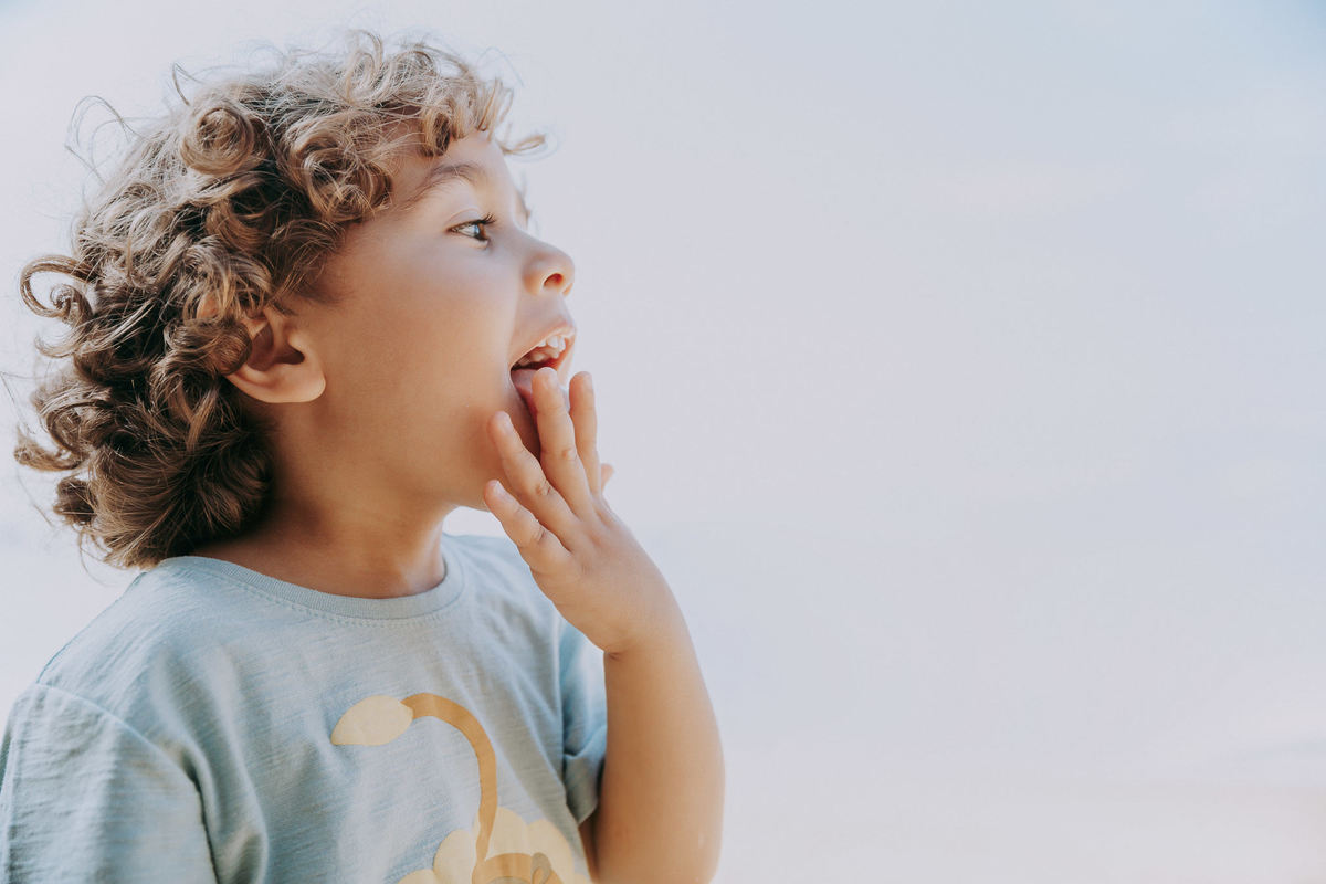 Fotografia de menino lambendo a mão