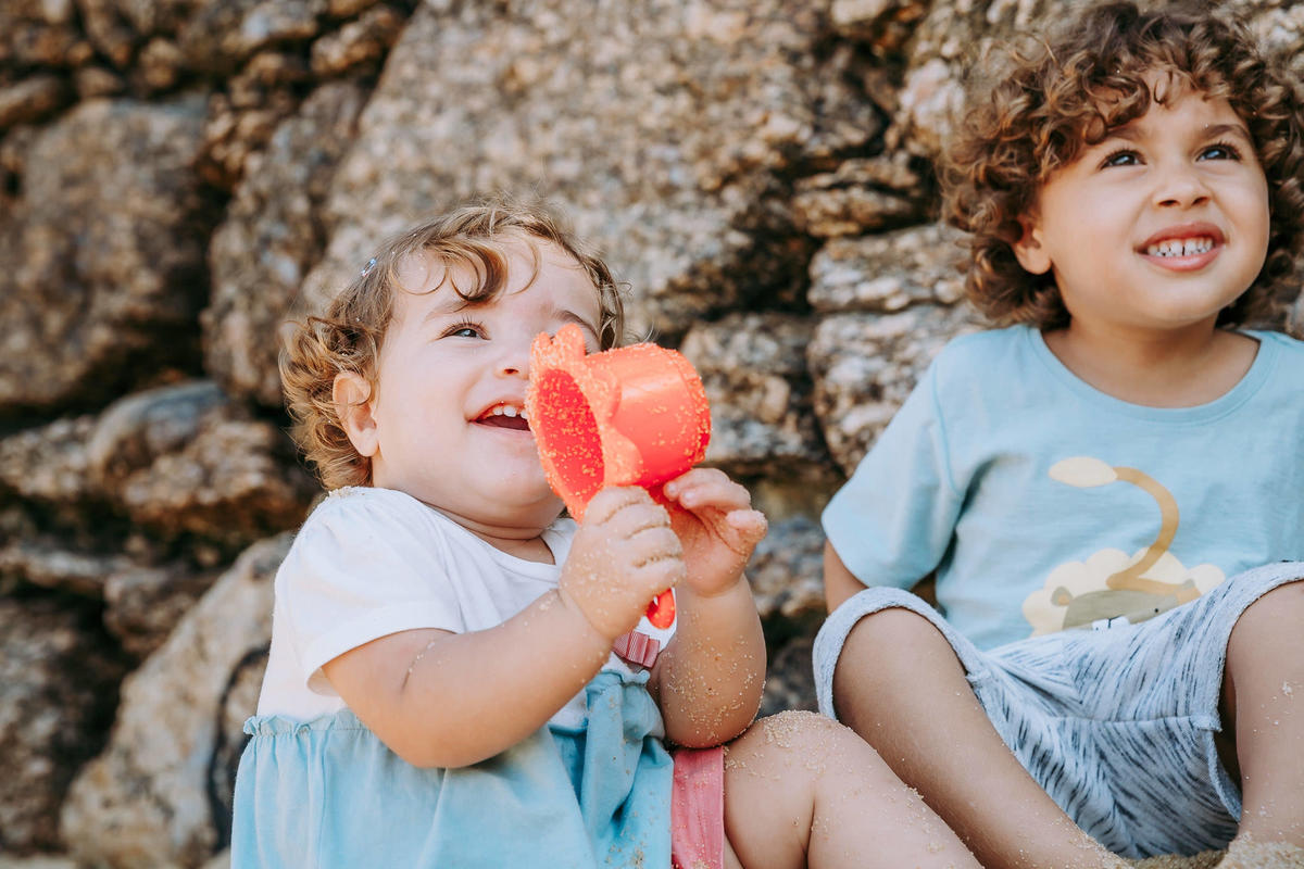 Fotografia de irmãos brincando na areia da Praia Vermelha no RJ durante ensaio fotográfico