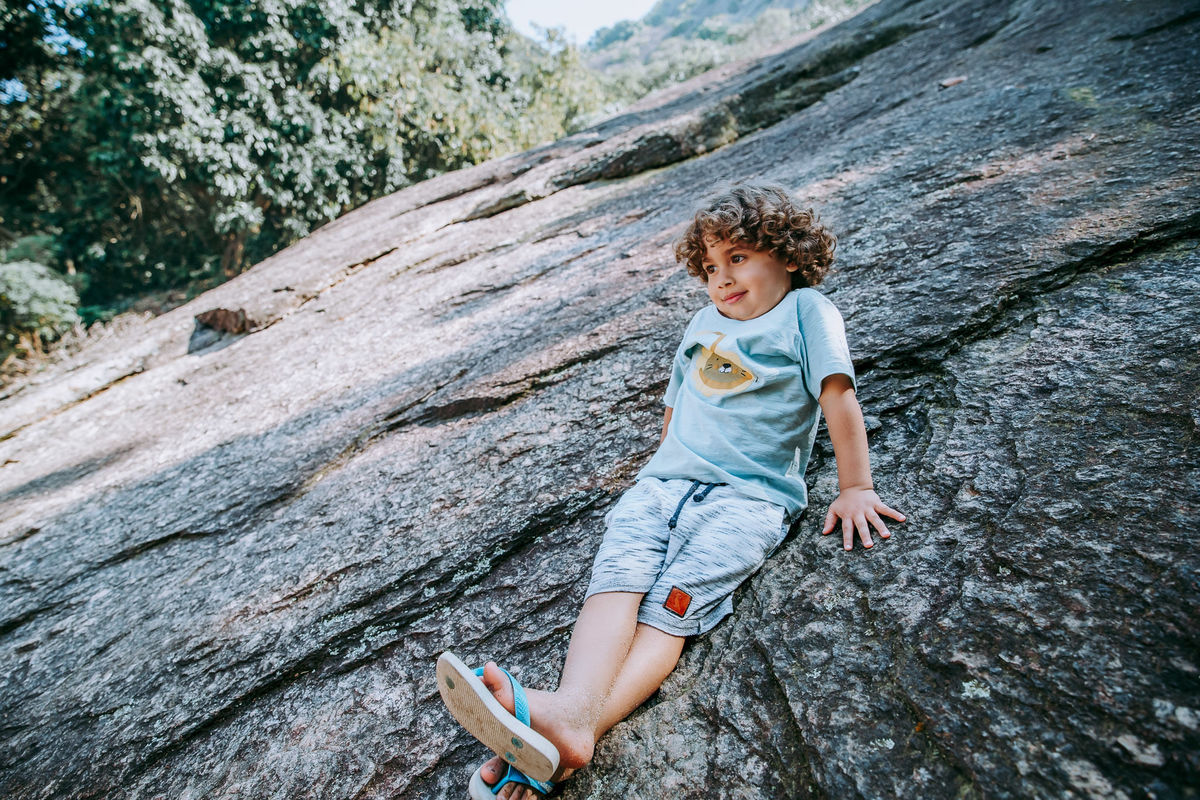 Fotografia de criança na pedra em ensaio fotográfico na Pista Claudio Coutinho no RJ