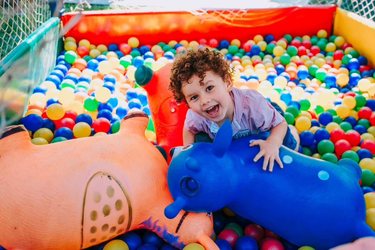 criança sorrindo na piscina de bolinhas