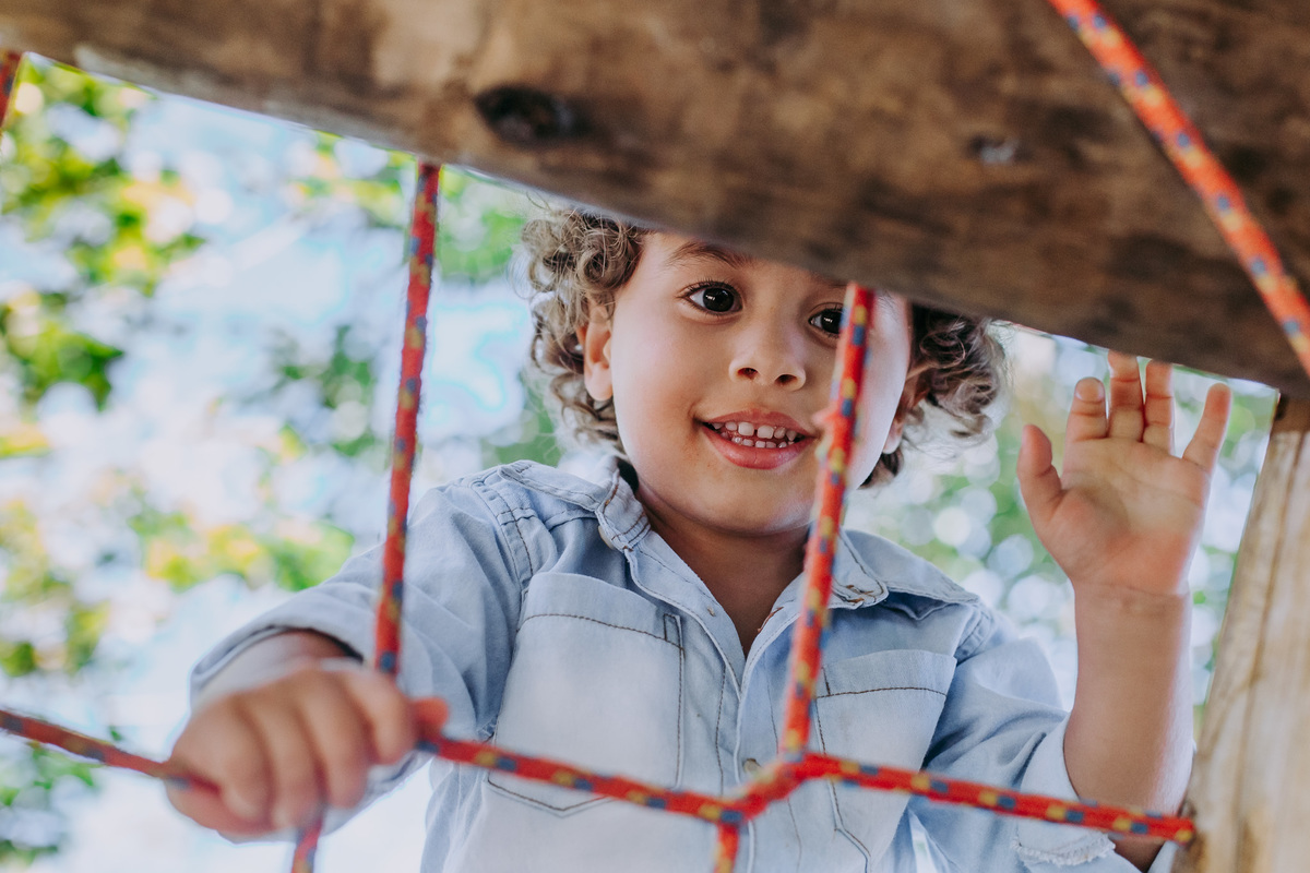 fotografia de criança subindo em escada de corda em seu aniversario de tres anos no sitio festa na flores em niteroi