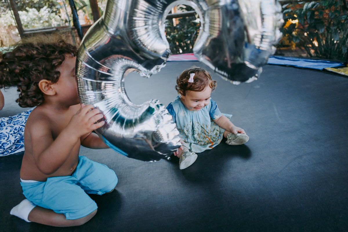 fotografia de irmãos pequenos no pula pula
