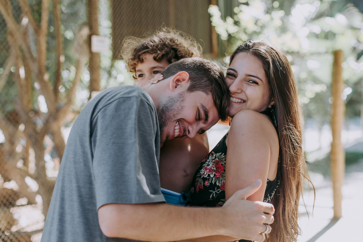 tios abraçando o sobrinho aniversariante com chamego