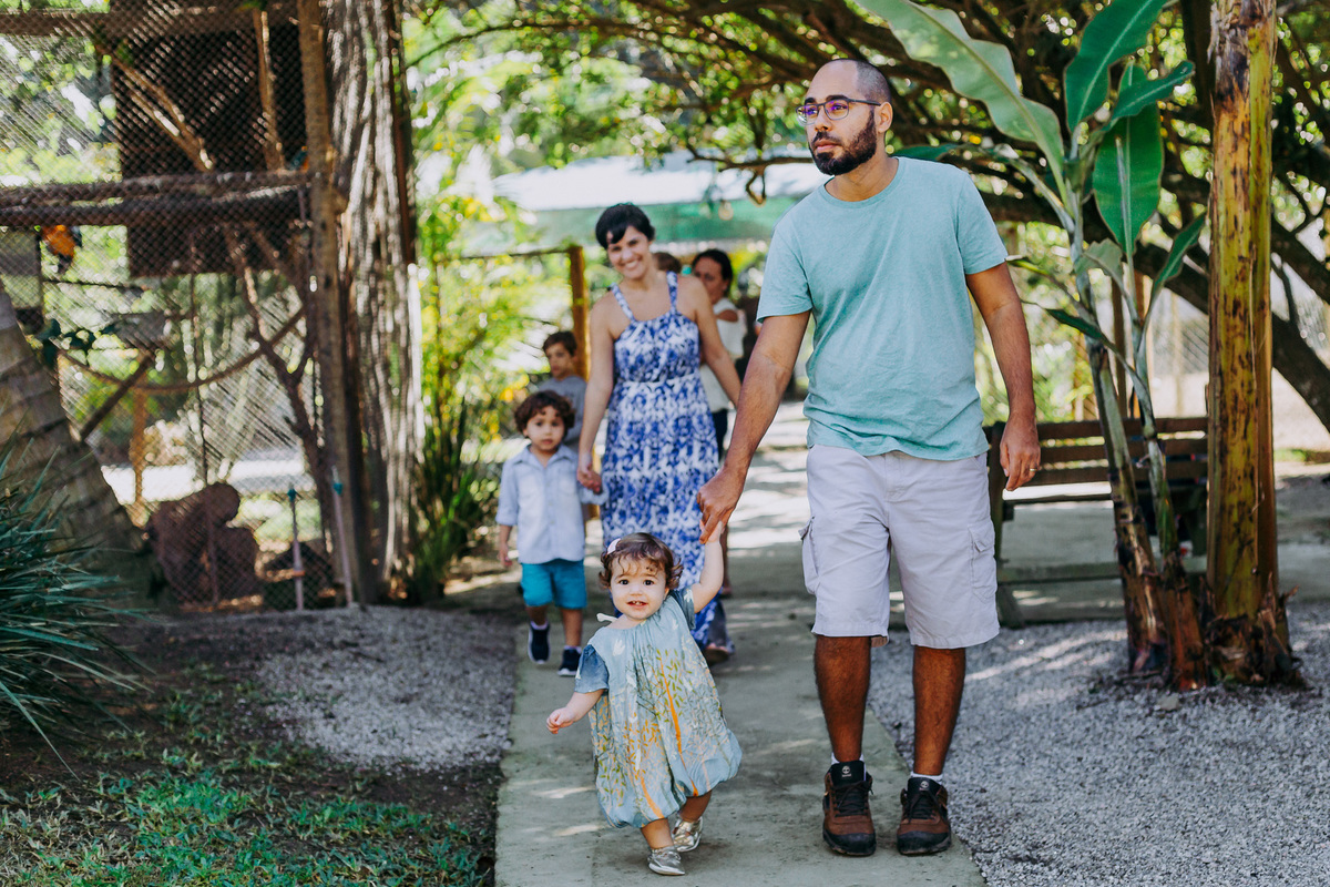 Fotografia dos aniversariantes chegando na festa com os pais