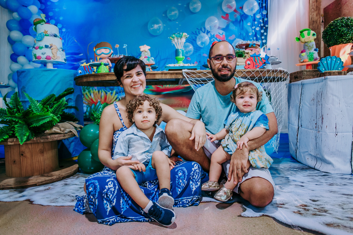 foto dos pais sentados no chão com os filhos