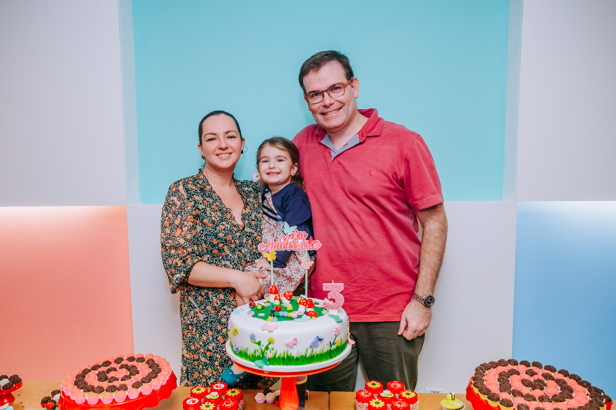 fotografia da familia na mesa do bolo em festa de aniversario infantil com tema joaninha