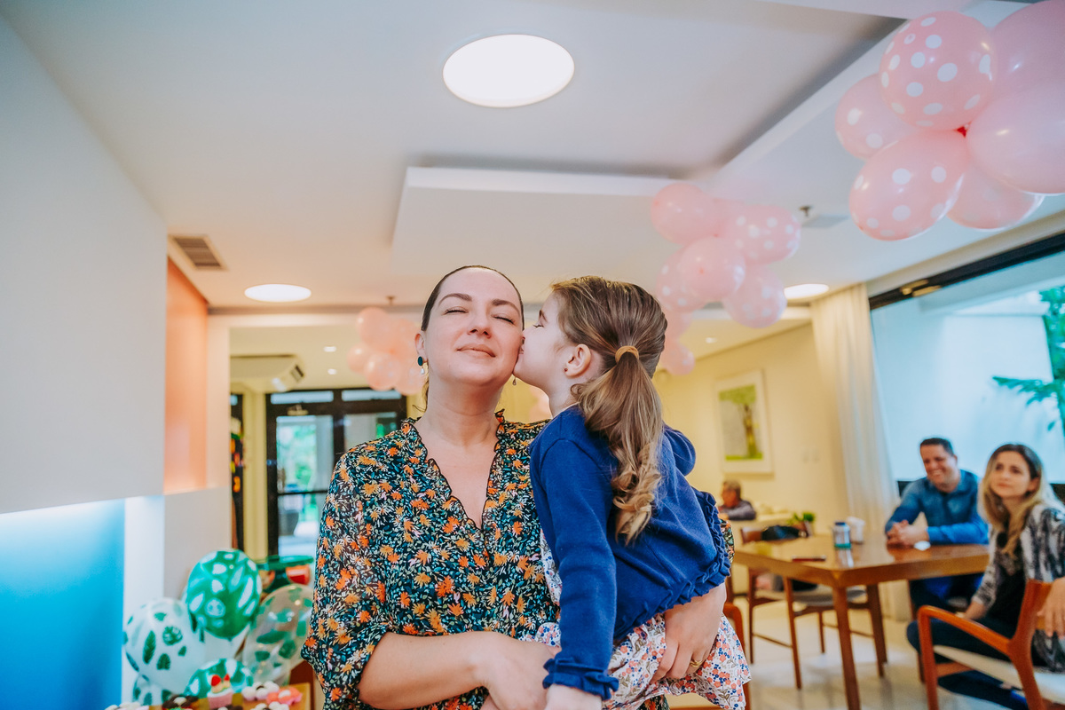 filha no colo da mãe beija a sua bochecha
