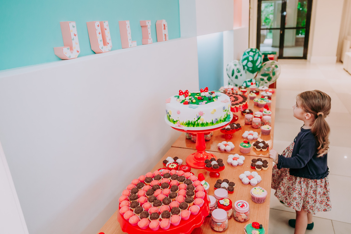 fotografia de criança olhando para mesa do bolo