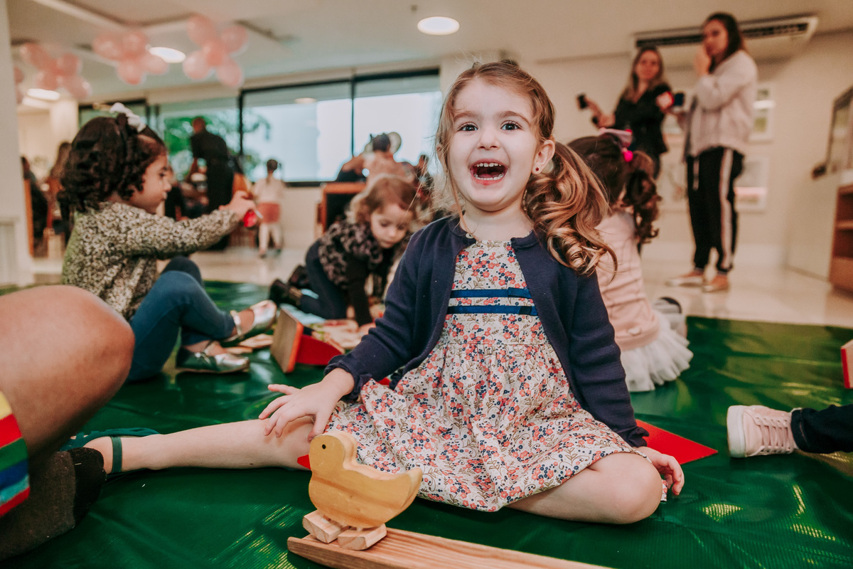 fotografia de menina sentada no chao sorrindo para a camera